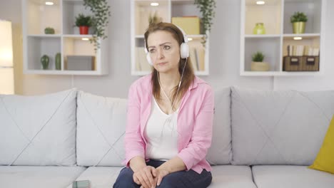 Woman-listening-to-music-with-headphones-is-unhappy-and-sad.
